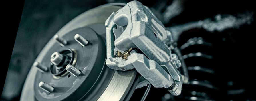 Silver brake caliper mounted on brake disc rotor showing professional installation and performance braking components