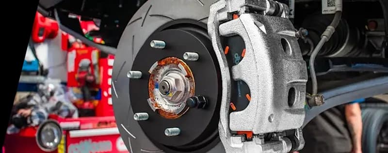 Performance brake system close-up showing DBA slotted rotor installed on vehicle with silver caliper and visible hub assembly