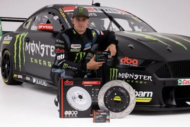 Tickford Racing Supercars driver posing with DBA brake disc products in front of Monster Energy Ford Mustang race car during 2022 partnership announcement