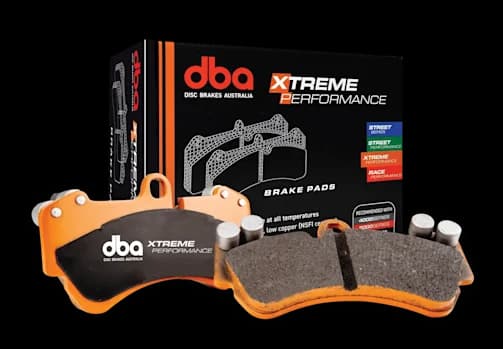DBA Xtreme Performance brake pads with orange backing plates and friction material displayed alongside retail packaging box